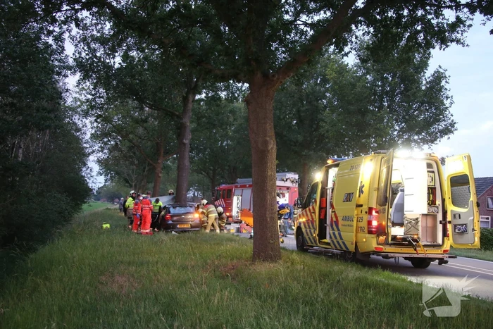 Bestuurder bekneld bij botsing tegen boom