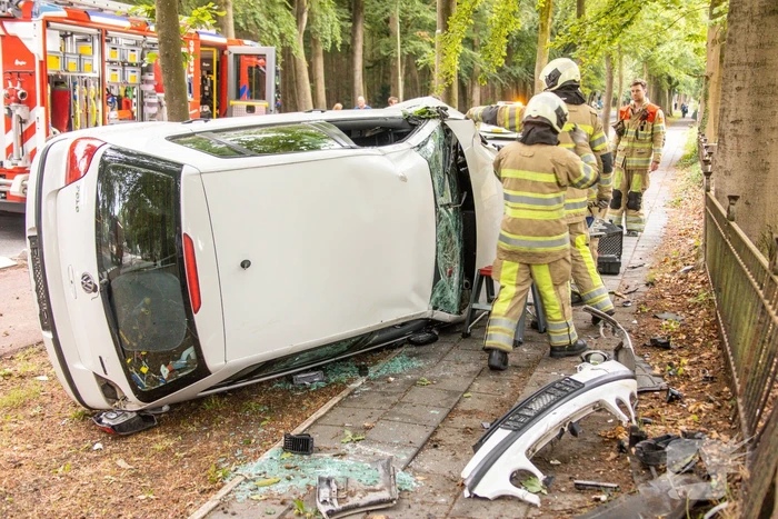 Auto crasht belandt op zijkant, bestuurder slaat op de vlucht