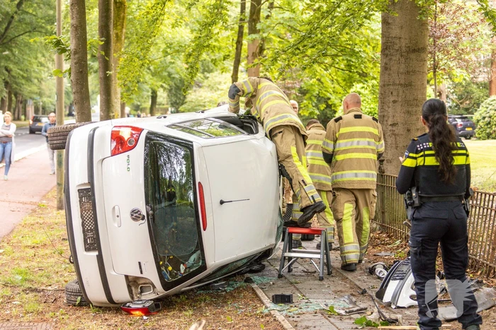 Auto crasht belandt op zijkant, bestuurder slaat op de vlucht