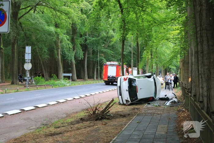Auto crasht belandt op zijkant, bestuurder slaat op de vlucht