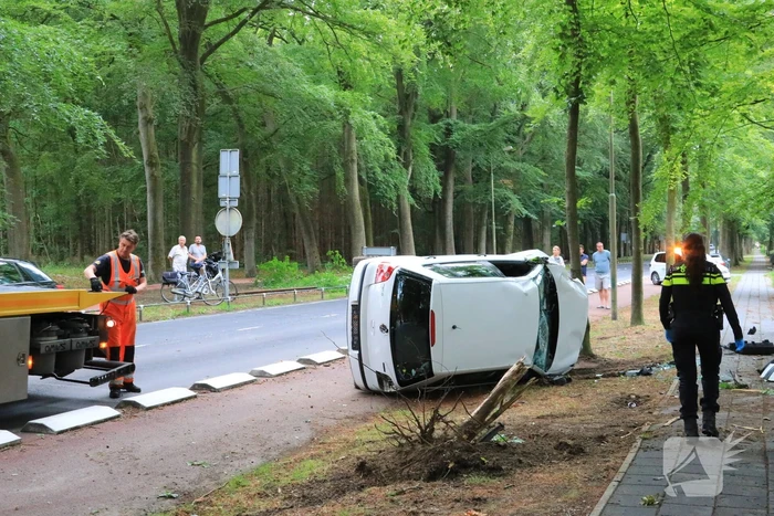 Auto crasht belandt op zijkant, bestuurder slaat op de vlucht