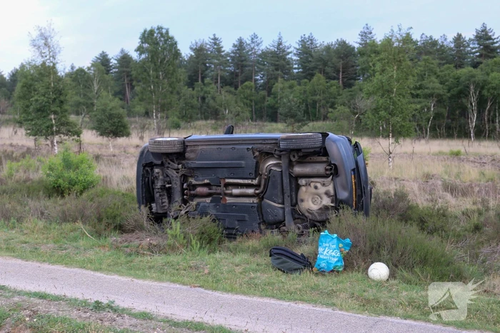 Auto belandt op kant in berm