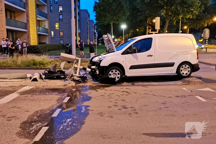 Bestelbus rijdt verkeerslicht uit de grond