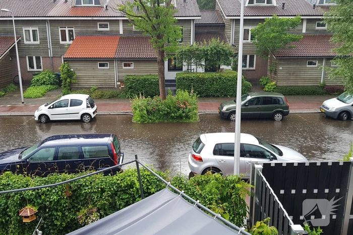 Straat onder water na wolkbreuk