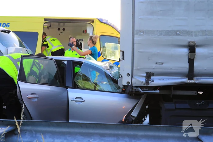 Auto schiet onder oplegger vrachtwagen