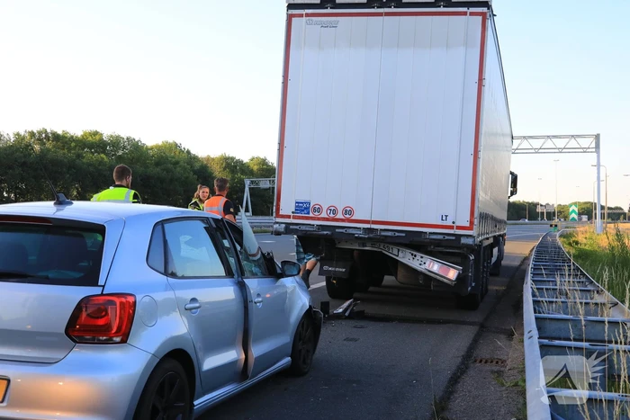 Auto schiet onder oplegger vrachtwagen