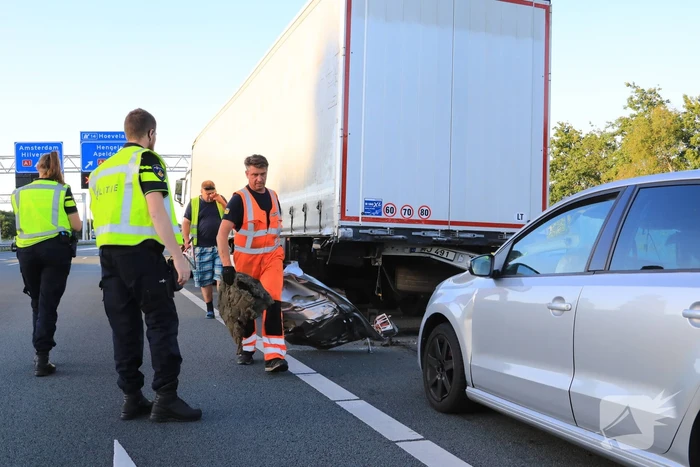 Auto schiet onder oplegger vrachtwagen