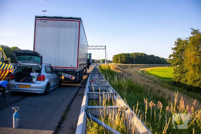 Auto schiet onder oplegger vrachtwagen