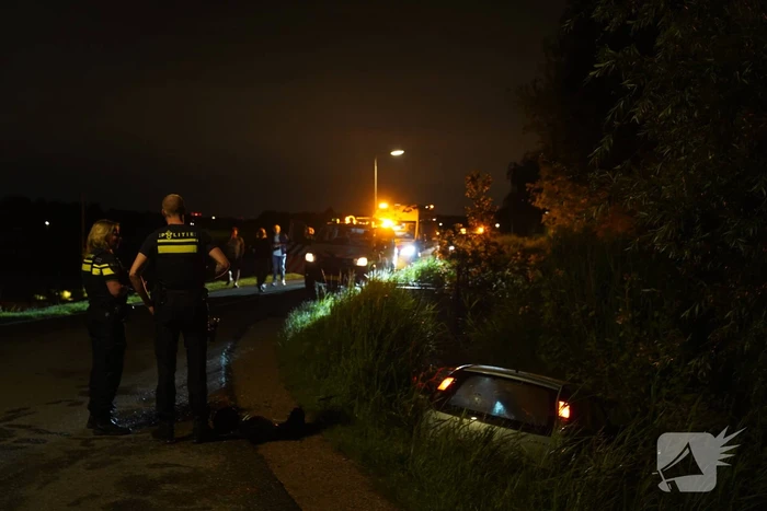 Auto te water na missen van bocht
