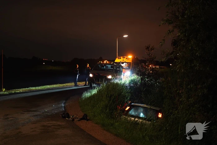 Auto te water na missen van bocht