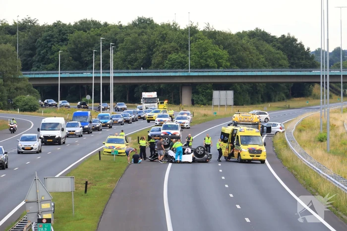 Auto op de kop na aanrijding op snelweg
