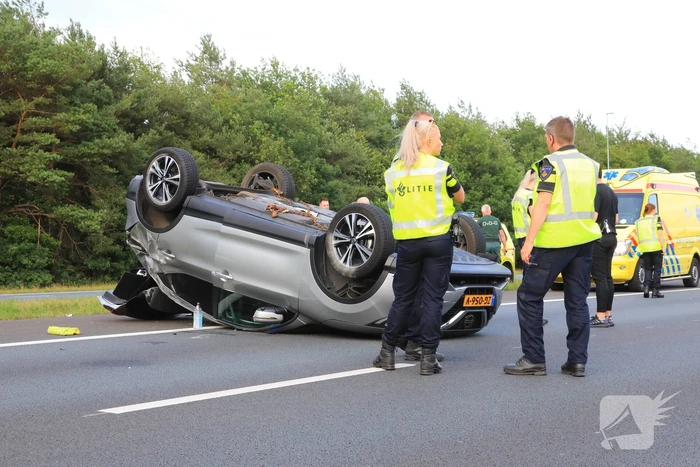 Auto op de kop na aanrijding op snelweg