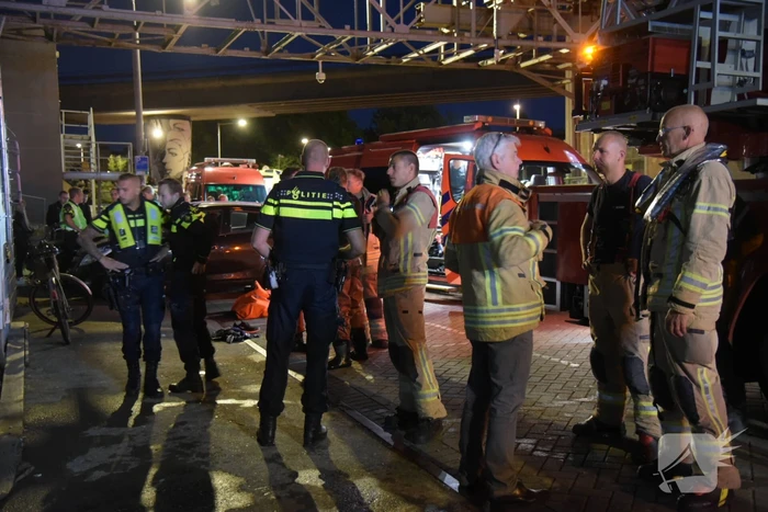 Omstanders halen persoon uit te water geraakte auto
