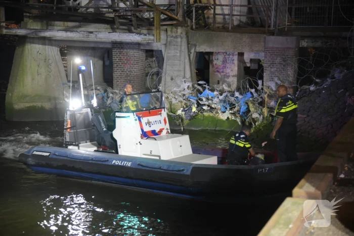 Omstanders halen persoon uit te water geraakte auto