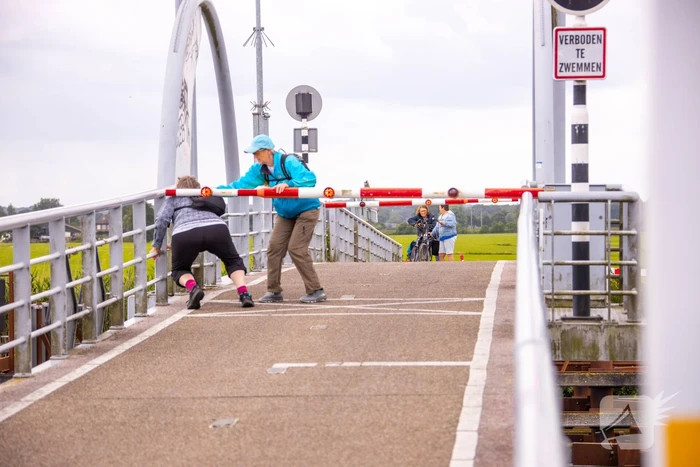 Fietsers kruipen onder slagbomen Malebrug