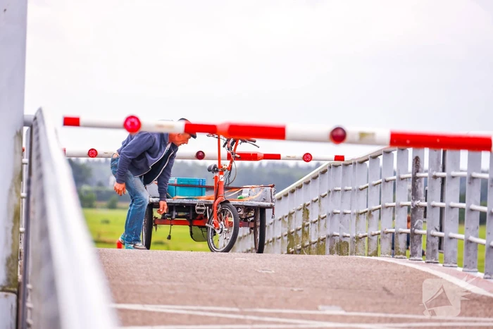 Fietsers kruipen onder slagbomen Malebrug