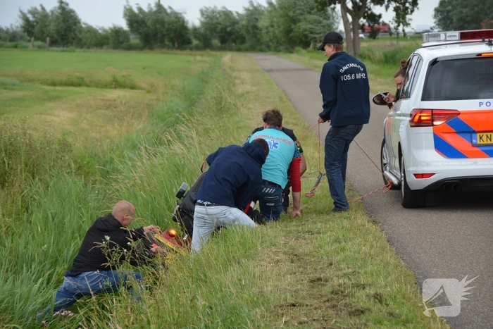 Omstanders halen scootmobiel uit greppel