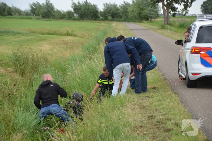 Omstanders halen scootmobiel uit greppel