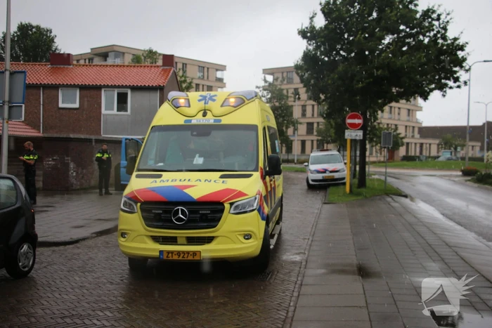 Boodschappenbus klapt achterop auto voor rotonde