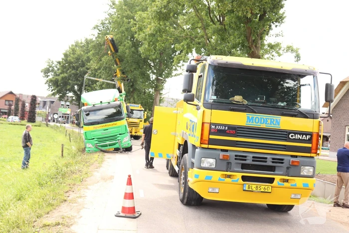 Vrachtwagen met bulkoplegger zakt weg in berm