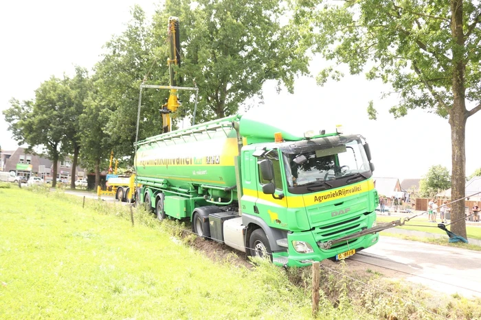 Vrachtwagen met bulkoplegger zakt weg in berm