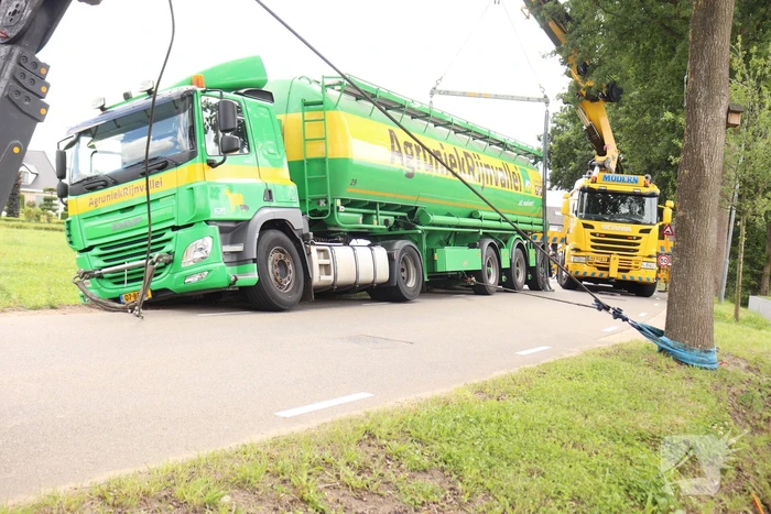 Vrachtwagen met bulkoplegger zakt weg in berm