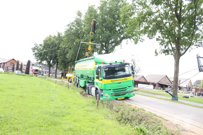 Vrachtwagen met bulkoplegger zakt weg in berm
