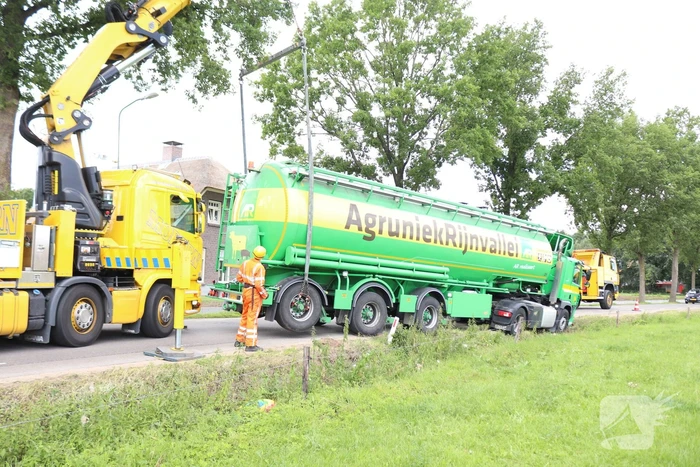 Vrachtwagen met bulkoplegger zakt weg in berm