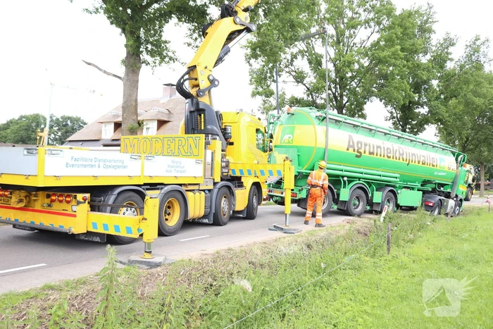 Vrachtwagen met bulkoplegger zakt weg in berm