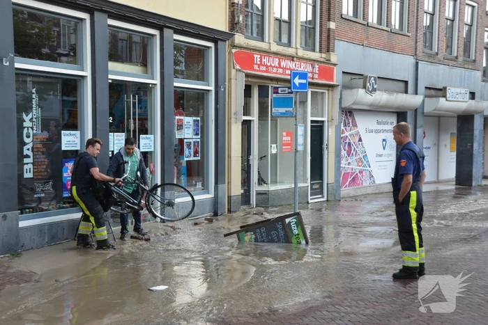 Winkelstraat blank na gesprongen waterleiding