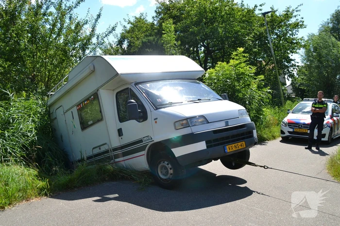 Camper rijdt achteruit de sloot in