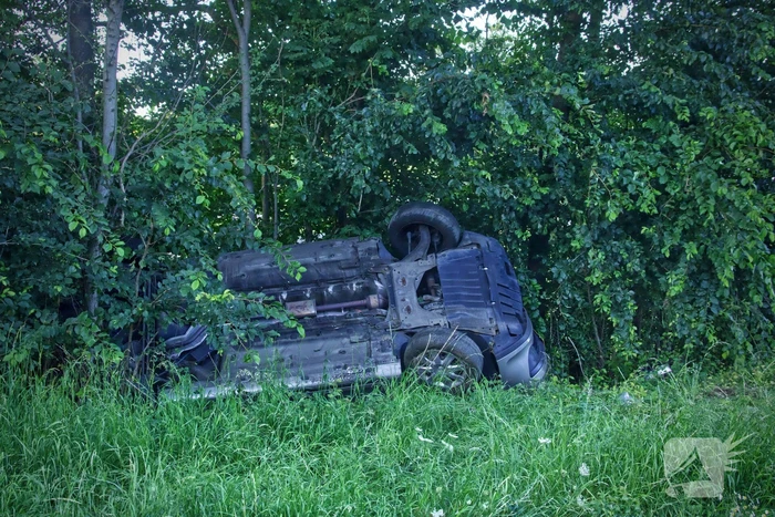 Auto slaat over de kop de berm in