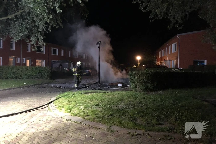 Stapel grofvuil laat lantaarnpaal branden