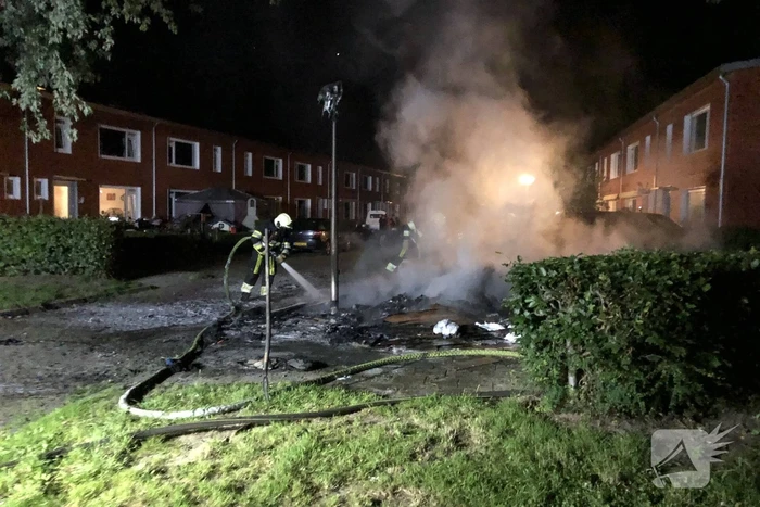 Stapel grofvuil laat lantaarnpaal branden