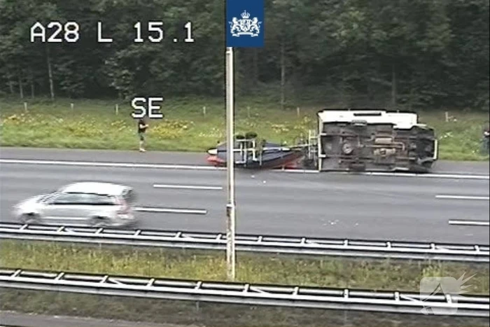 Belgische camper met boot op aanhanger gekanteld op snelweg