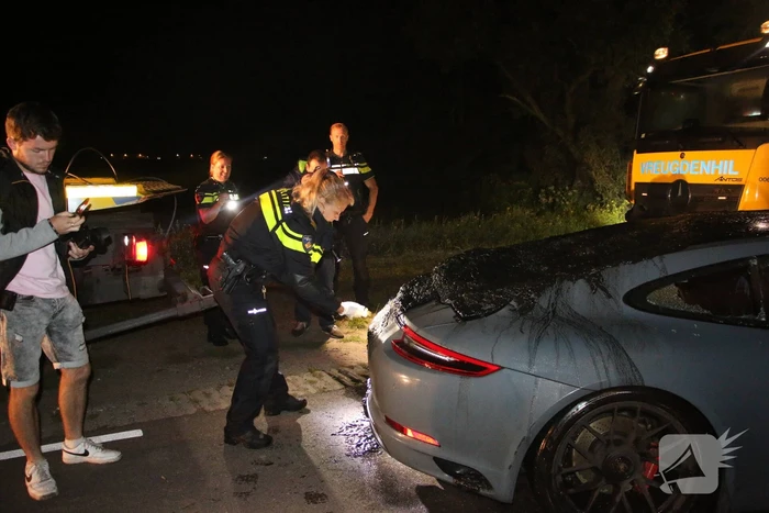 Peperdure Porsche belandt in de vaart na ontwijken van een dier