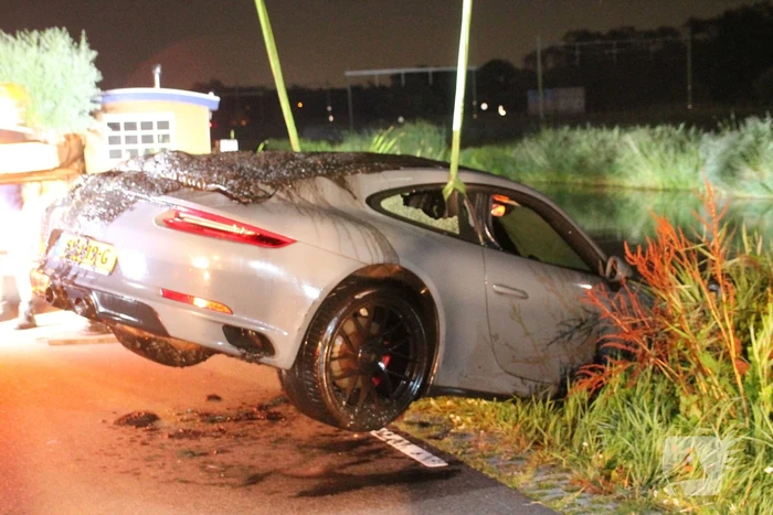 Peperdure Porsche belandt in de vaart na ontwijken van een dier