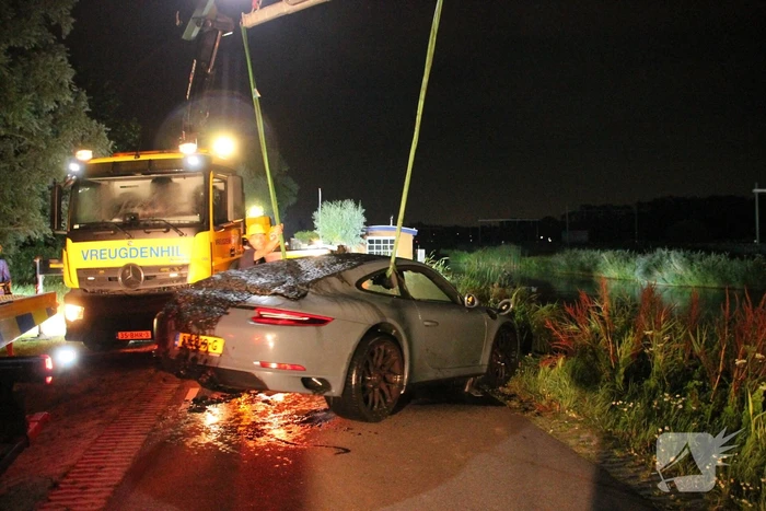Peperdure Porsche belandt in de vaart na ontwijken van een dier