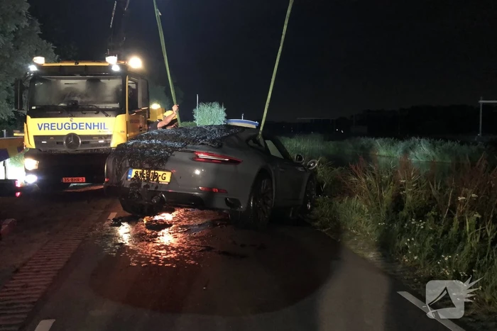 Peperdure Porsche belandt in de vaart na ontwijken van een dier
