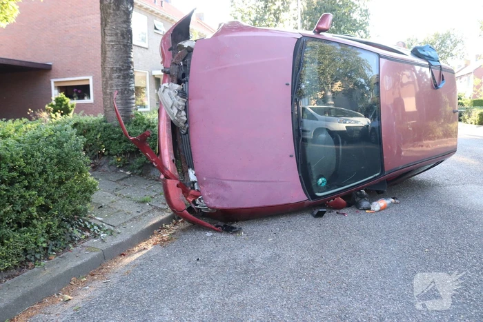 Bestuurder raakt onwel, botst op geparkeerde auto en belandt op zijn kant