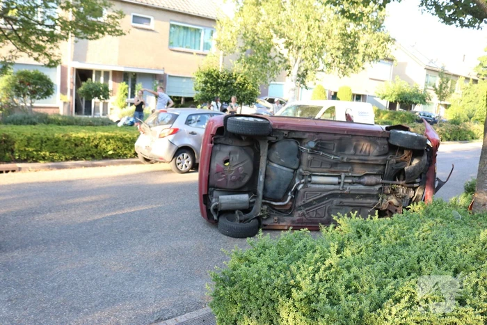 Bestuurder raakt onwel, botst op geparkeerde auto en belandt op zijn kant