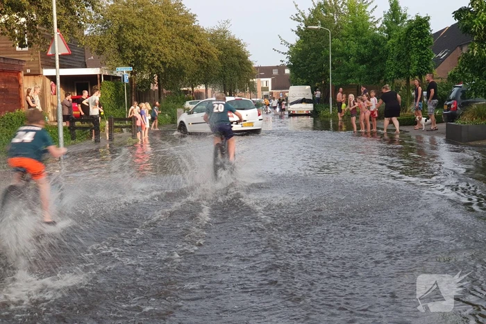 Jeugd vermaakt zich in ondergelopen straat
