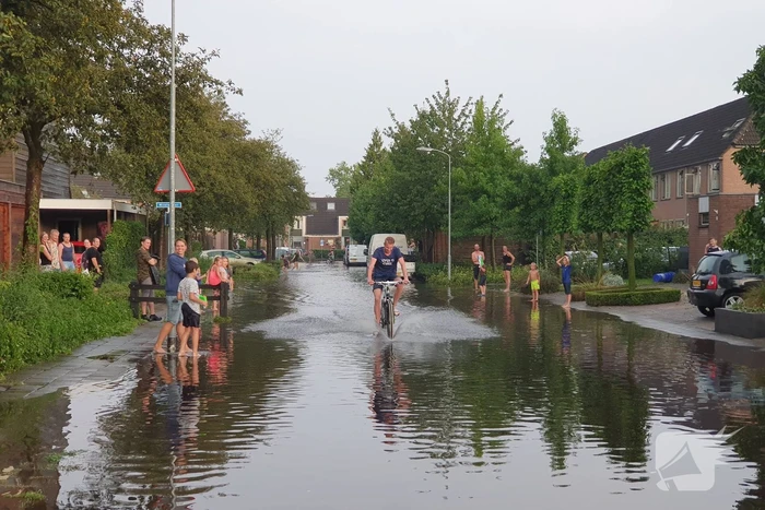 Jeugd vermaakt zich in ondergelopen straat