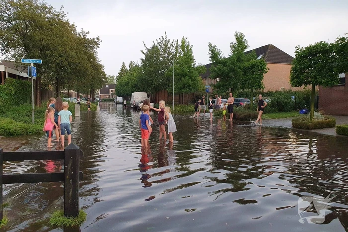 Jeugd vermaakt zich in ondergelopen straat