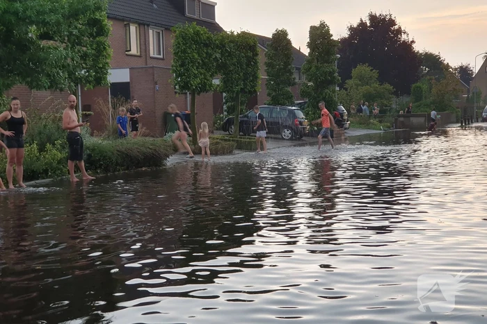 Jeugd vermaakt zich in ondergelopen straat