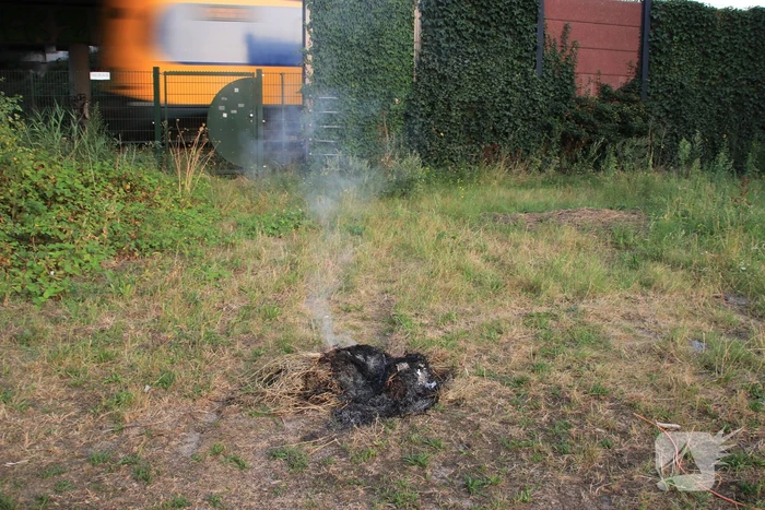 Buurtbewoner blust een hoop in brand gevlogen hooi