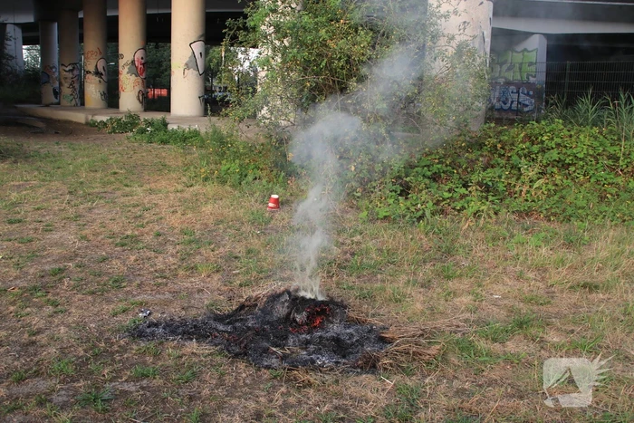 Buurtbewoner blust een hoop in brand gevlogen hooi