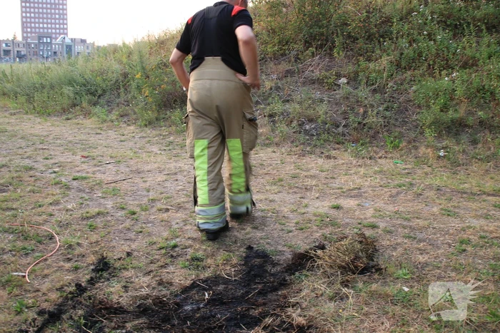 Buurtbewoner blust een hoop in brand gevlogen hooi