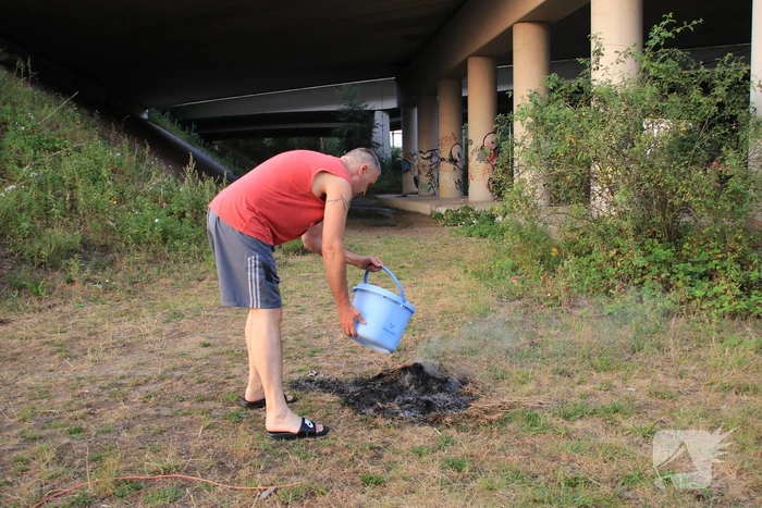 Buurtbewoner blust een hoop in brand gevlogen hooi