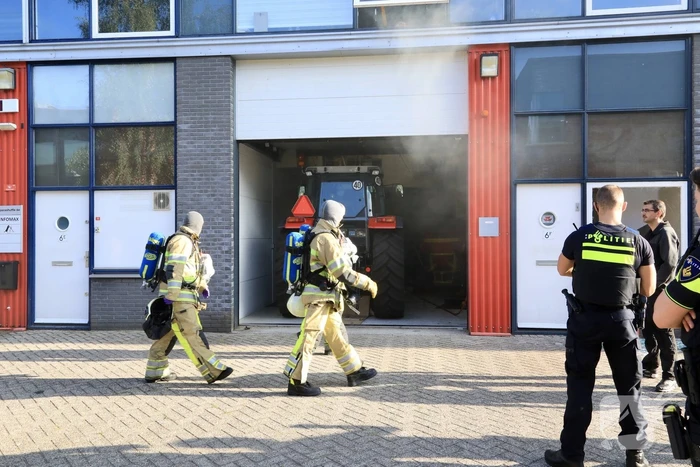 Medewerkers blussen brand in bedrijfsverzamelgebouw